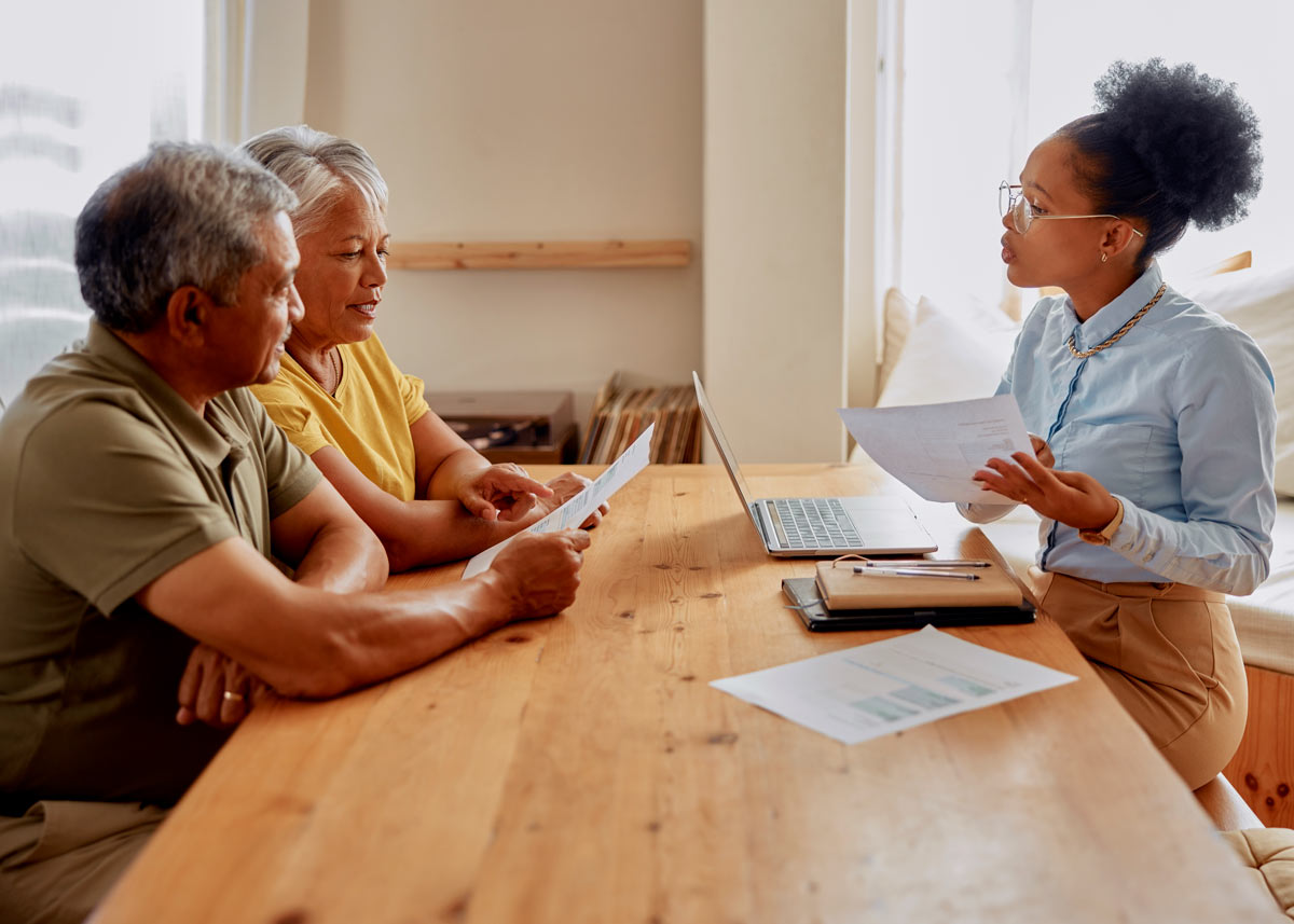 mature black couple sits with young female banker